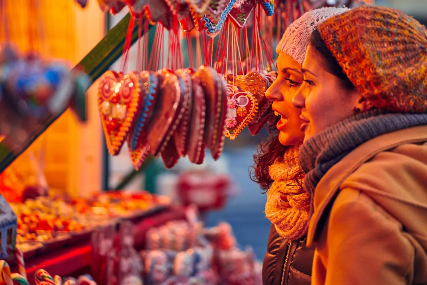 Dos mujeres paseando por un mercadillo navideño de España/ CANVA