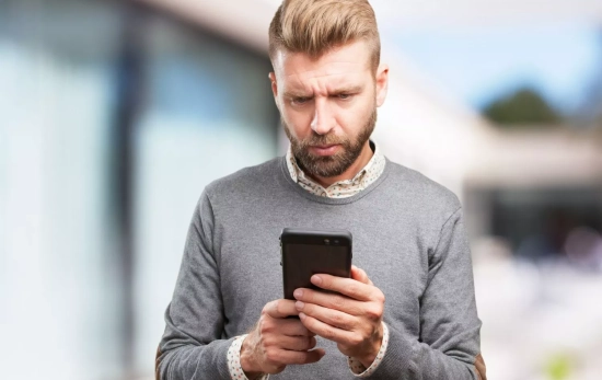 Un hombre mira su móvil / FREEPIK