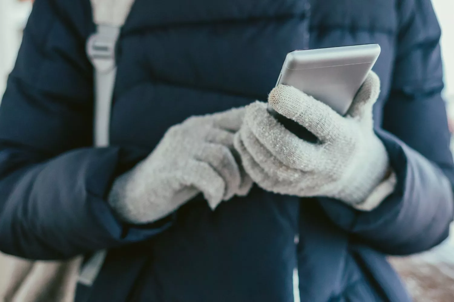 Una persona que sabe cómo proteger su móvil del frío este invierno/ CANVA