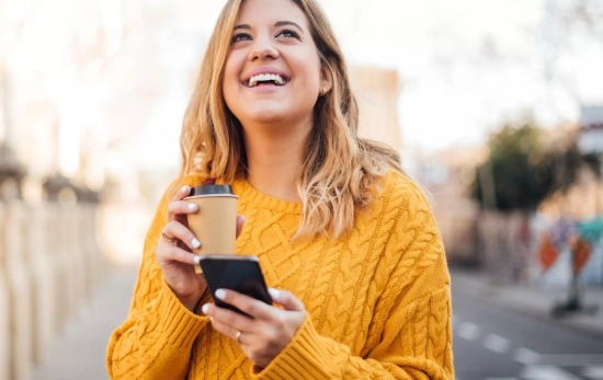 Una persona con su teléfono en la calle con el frío de invierno/ CANVA Una persona con su teléfono en la calle con el frío de invierno/ CANVA