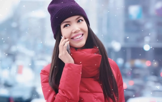 Una persona hablando con su teléfono en la calle durante una nevada/ CANVA Una persona hablando con su teléfono en la calle durante una nevada/ CANVA