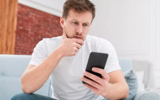 Un hombre mira su teléfono móvil / FREEPIK Un hombre mira su teléfono móvil / FREEPIK