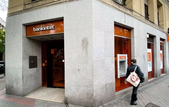Una mujer camina junto a una oficina del Bankinter en Madrid Una mujer camina junto a una oficina del Bankinter en Madrid