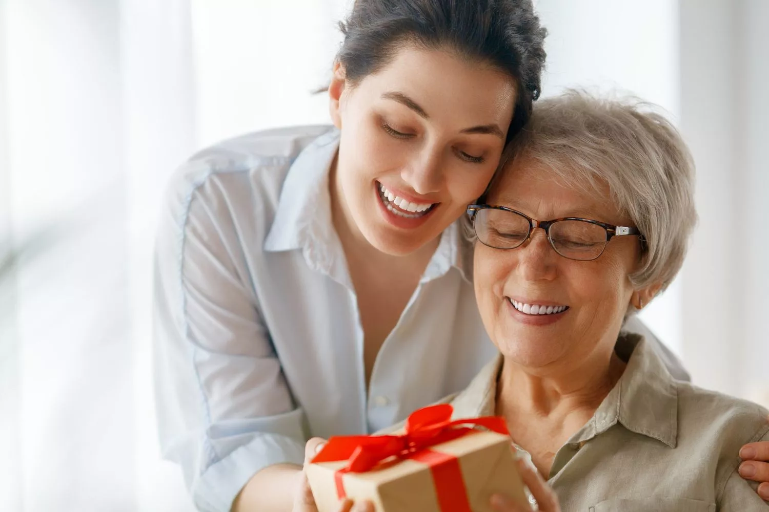 Una chica sorprende a su madre con un regalo en Navidad / CANVA