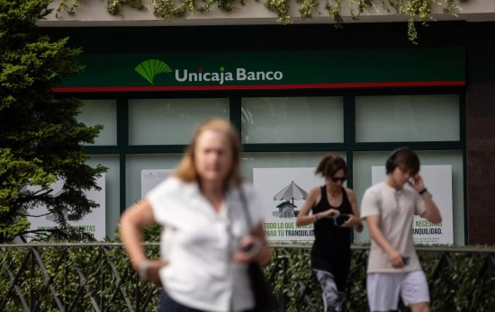 Varias personas junto a una oficina de Unicaja / EUROPA PRESS