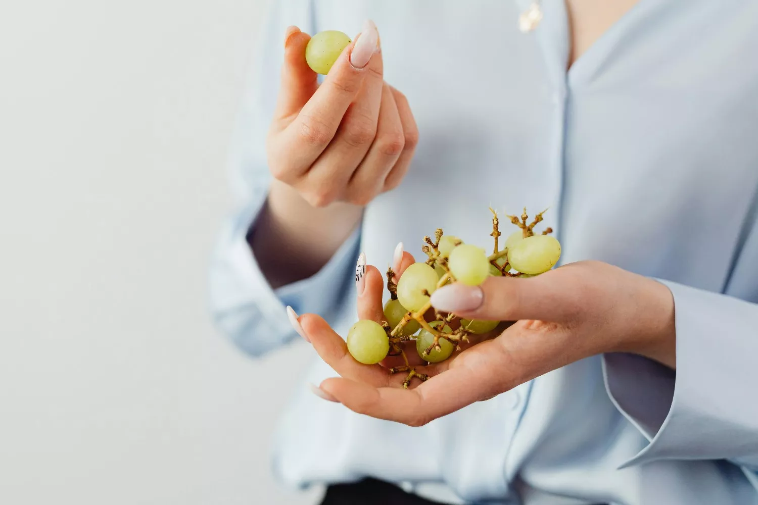 Una persona con unas uvas / PEXELS