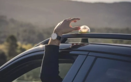 Un conductor coloca la baliza V16 en su coche a a