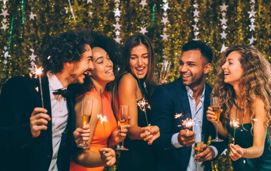 Una grupo de personas celebrando la Nochevieja/ CANVA