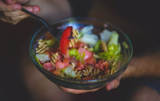 Una persona comiendo ensalada/ CANVA