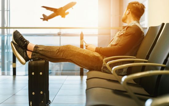 Un pasajero observa un avión apoyado en su maleta de mano / Unsplash Un pasajero observa un avión apoyado en su maleta de mano / Unsplash