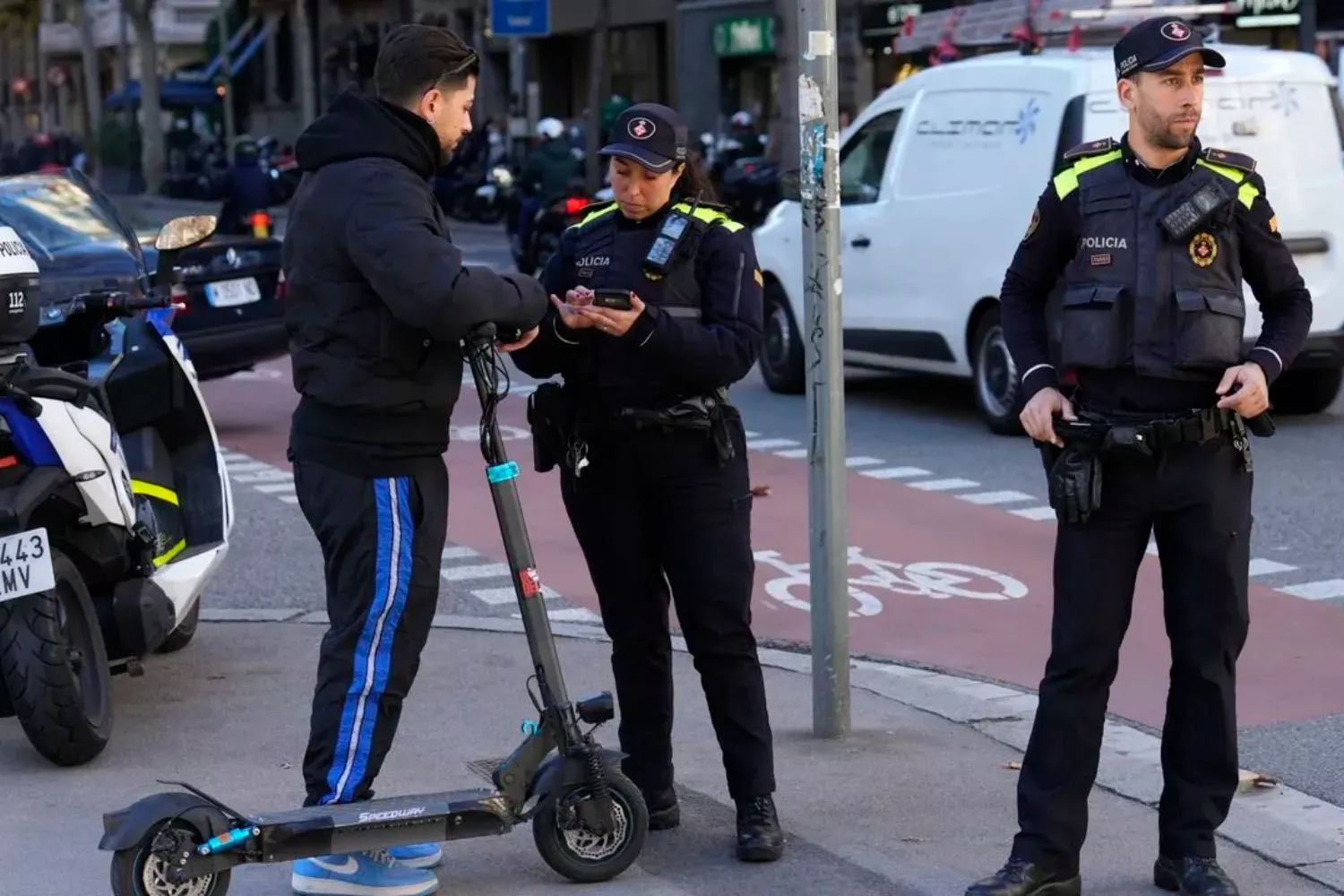 Agentes de la Guardia Urbana de Barcelona denuncian a un usuario de patinete eléctrico / Alejandro García - EFE