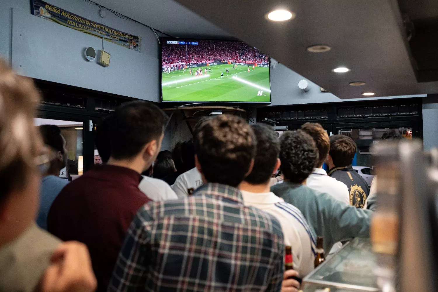 Varias personas disfrutan de la emisión del partido / EUROPA PRESS - DIEGO RADAMÉS