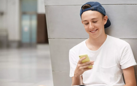 Un adolescente mira su móvil / FREEPIK - wayhomestudio