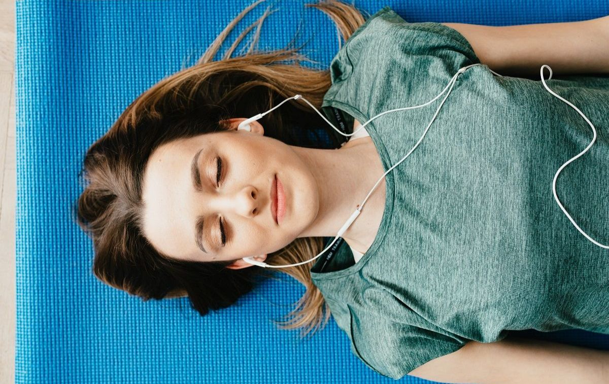 Una mujer practica mindfulness escuchando música / PEXELS