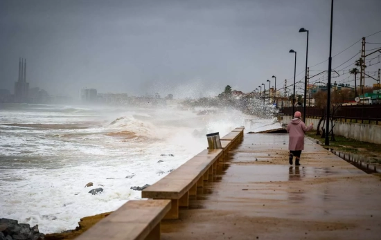 Una persona pasea en el paseo marítimo de playa Barca María afectado por el temporal marítimo en la