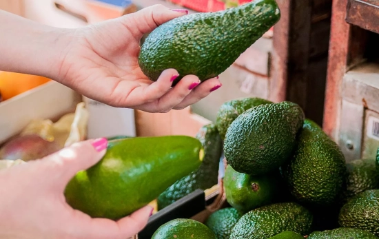 Una persona compra aguacates
