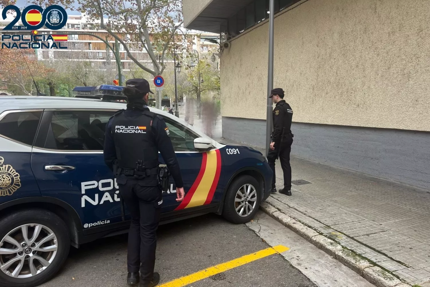 Dos agentes frente a un coche de la Policía Nacional / POLICÍA NACIONAL - EP