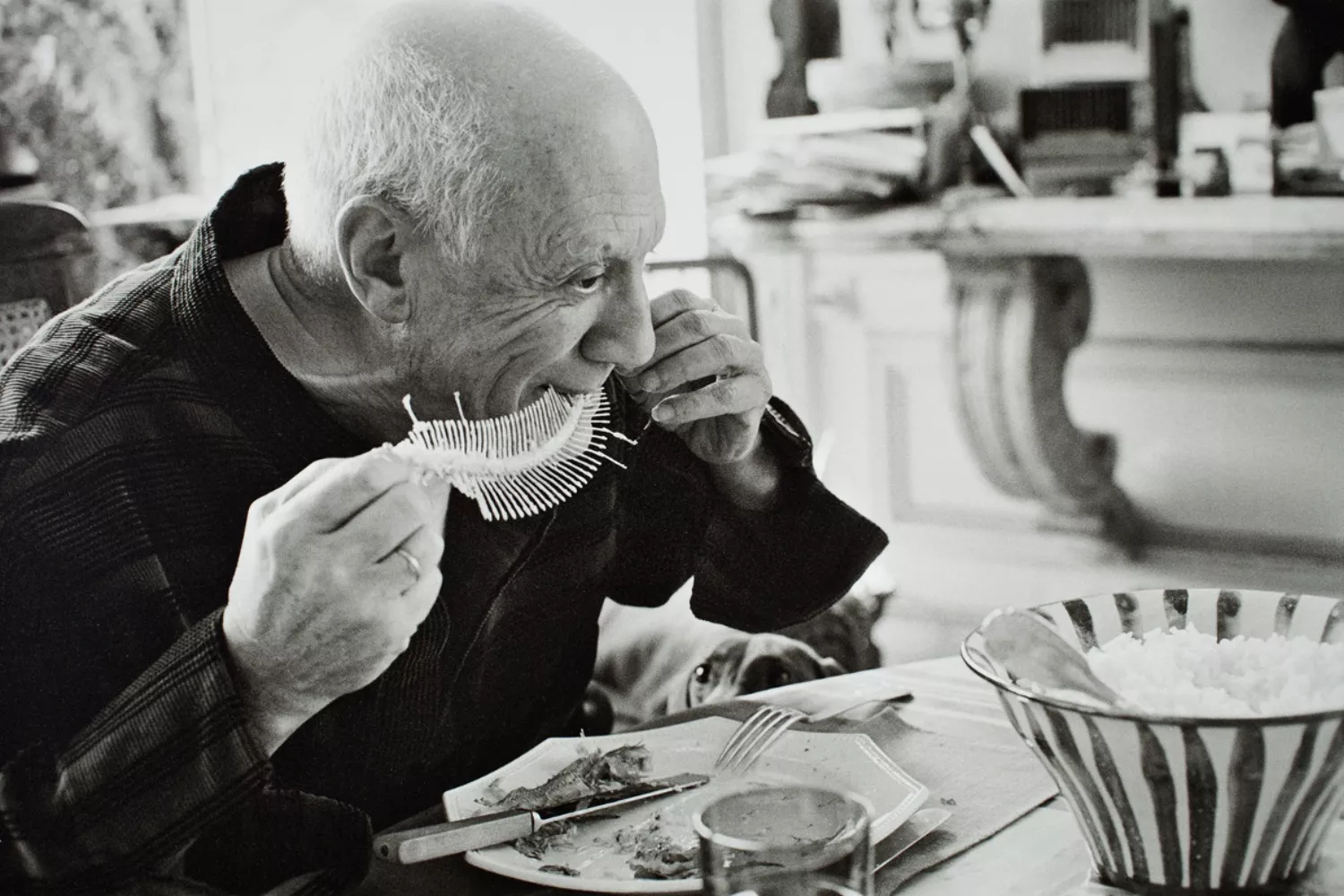 Retrato tomado por David Douglas Duncan de Picasso comiendo para su obra 'Plato con fósil de pez' / SUCESIÓN PICASSO