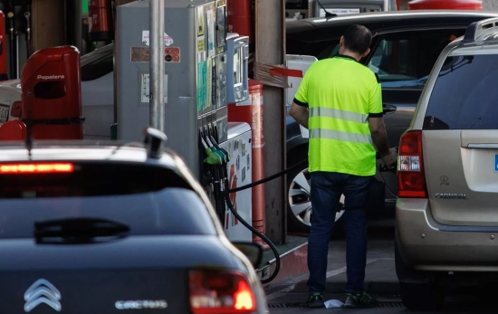 Un hombre echa carburante a su vehículo en una gasolinera,