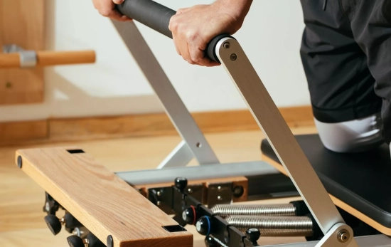 Una persona usando el Reformer de Pilates/ CANVA