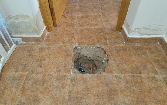 El agujero en el suelo del pasillo realizado por operarios de Kutxabank CEDIDA