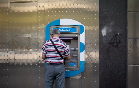Un hombre saca dinero en un cajero