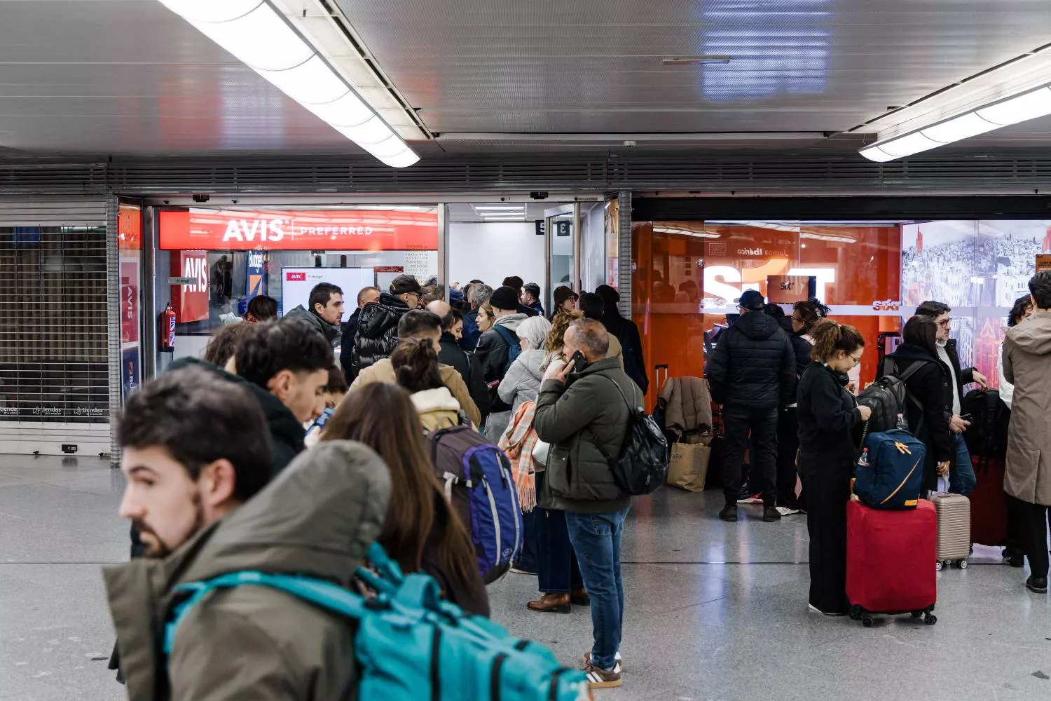 Varias personas hacen cola en unas oficinas de alquiler de coches   EP