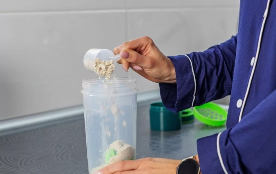 Una persona tomando creatina en un batido/ CANVA