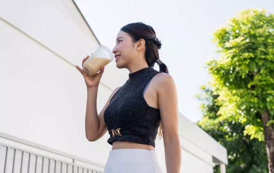 Una mujer tomando un batido con suplementación/ CANVA