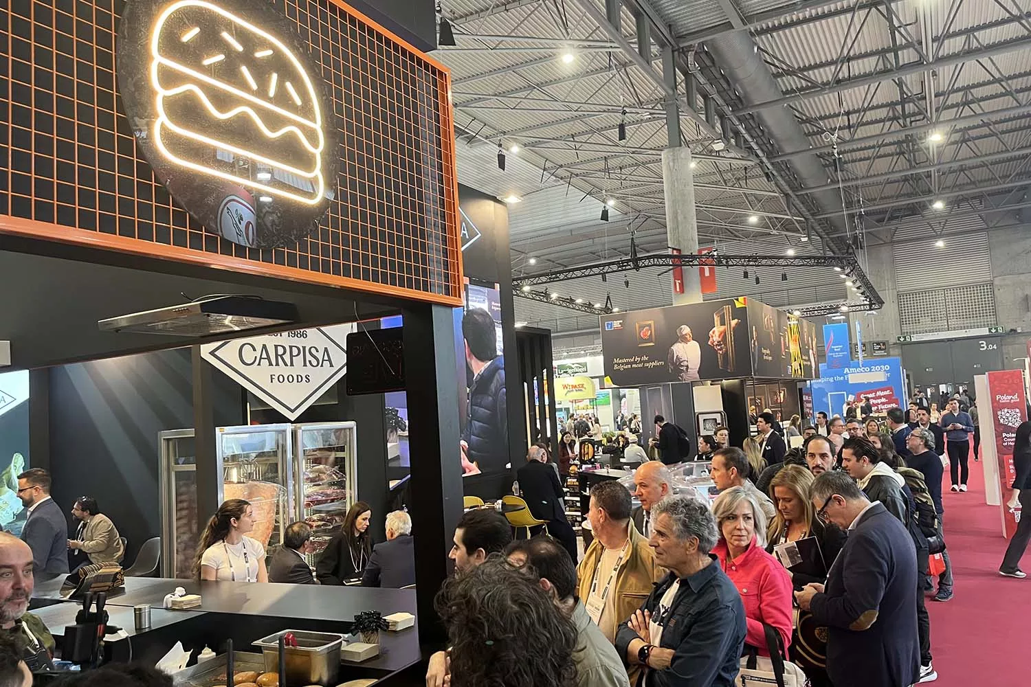 La cola para coger un trozo de hamburguesa de Carpisa Foods gratis en Alimentaria TEO CAMINO