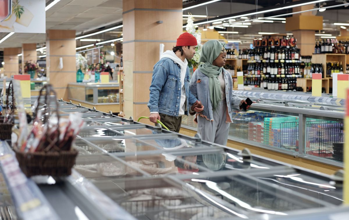 Una pareja revisa los productos de un supermercado / PEXELS