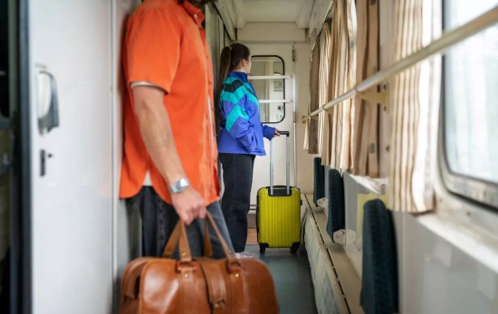 Varias personas con maletas en un tren / FREEPIK