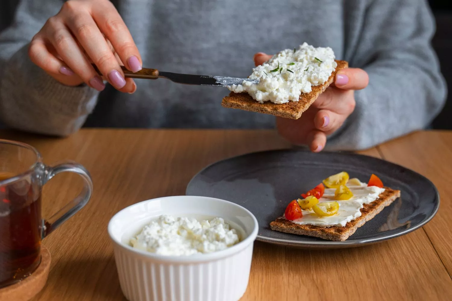 Una persona prepara una tostada con queso cottage