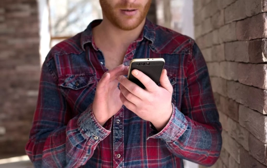 Una persona mira su móvil / FREEPIK - LipikStockMedia