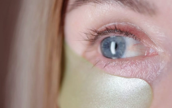 Una mujer poniéndose un tratamiento en el contorno de ojos/ CANVA