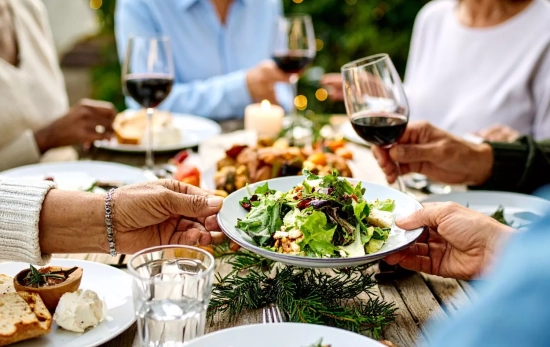 Una reunión familiar donde beben la bebida sin alcohol estilo vino tinto de Mercadona/ CANVA