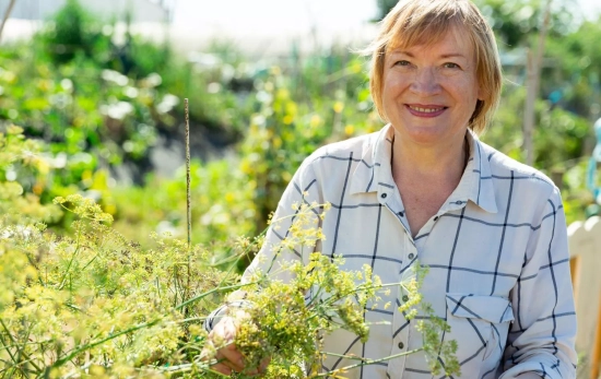 Una mujer disfrutando de la jardinería/ CANVA Una mujer disfrutando de la jardinería/ CANVA