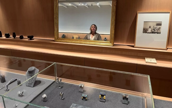 Una vitrina con joyas y el reflejo de Caroline enmarcado en el espejo / TC