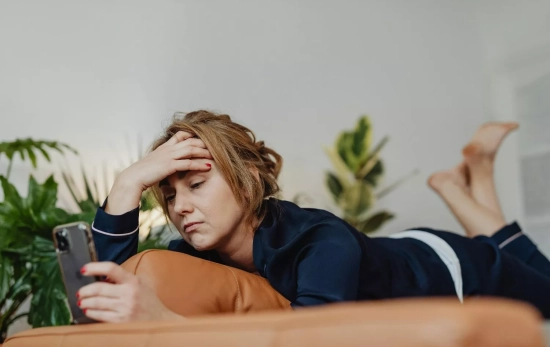 Una persona mira su móvil con desagrado / PEXELS