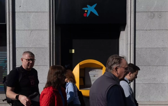 Varias personas pasan delante de un cajero CaixaBank / EUROPA PRESS - EDUARDO PARRA