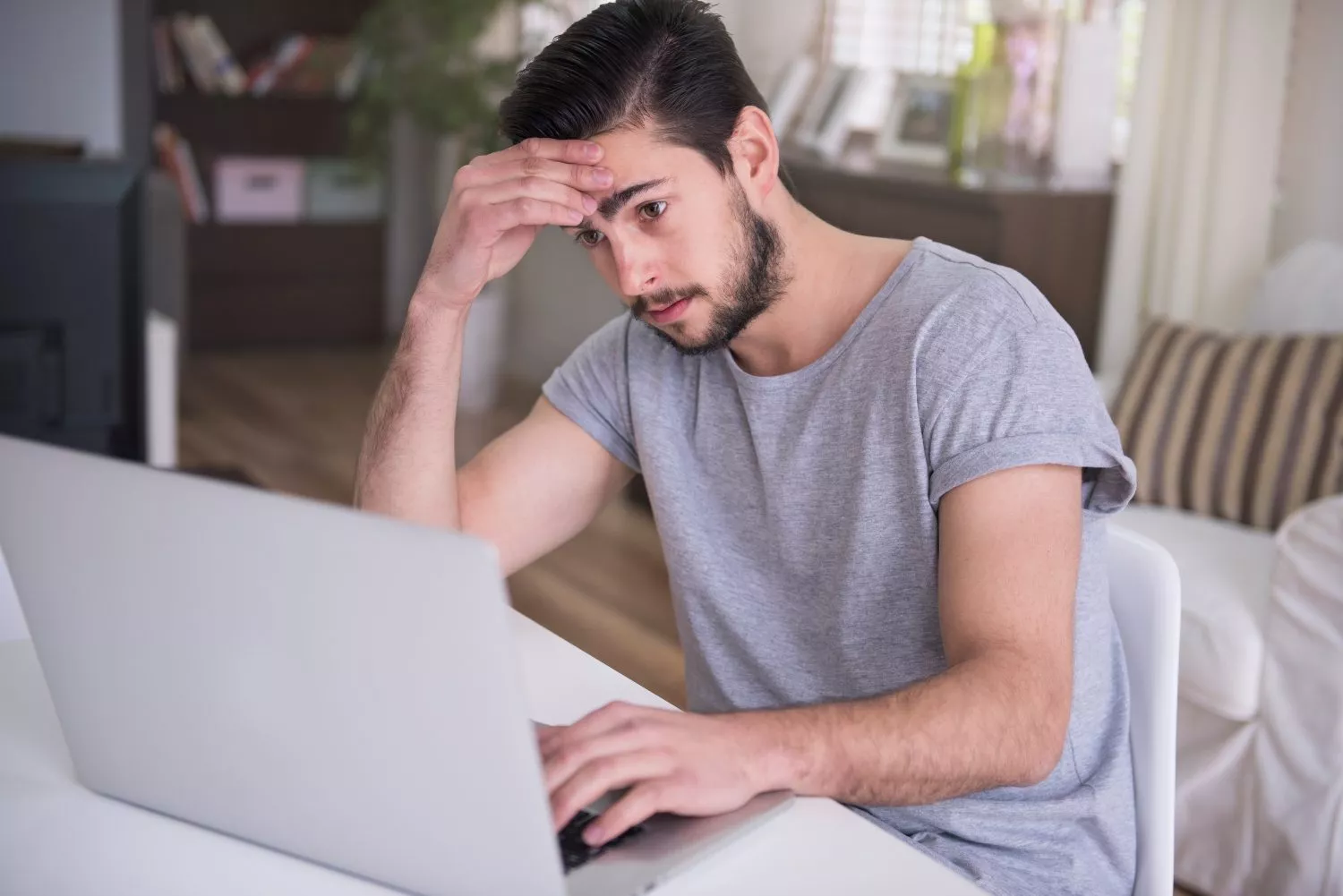 Un joven frustrado al descubrir que su banco le cobra por emitir el certificado de titularidad bancaria / FREEPIK