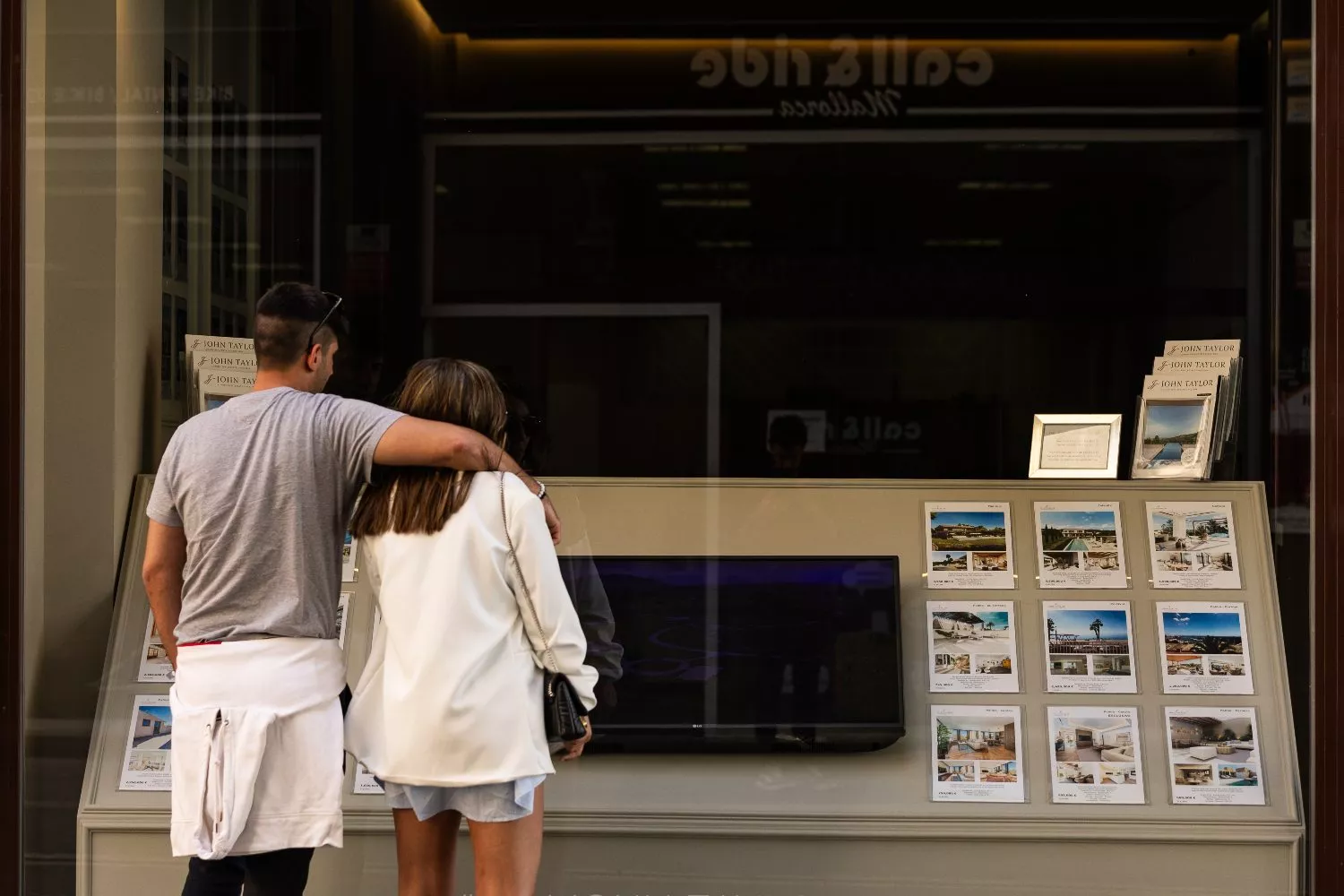 Dos personas observan los anuncios de viviendas en venta en una inmobiliaria (3)
