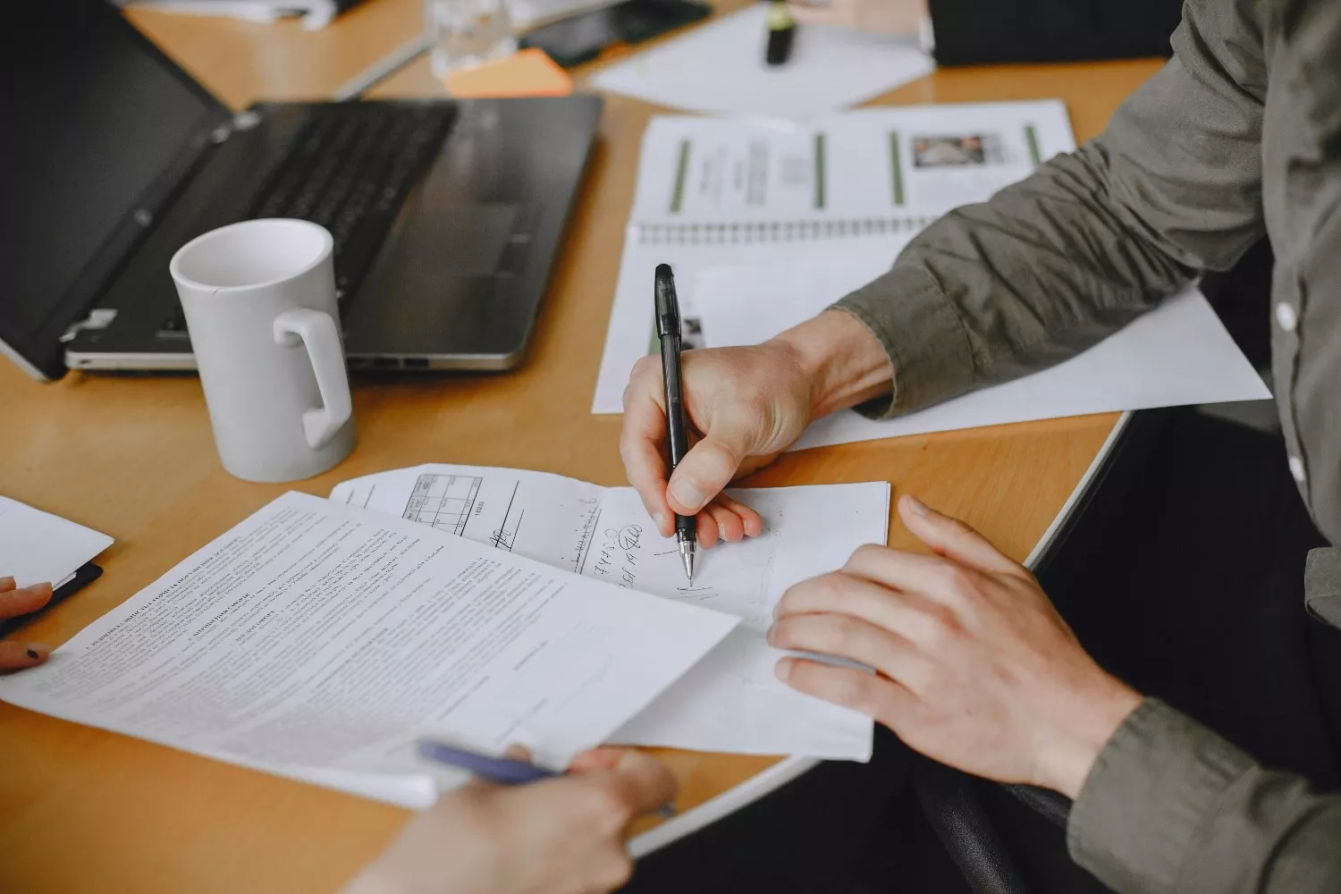 Una persona firma unos documentos   FREEPIK
