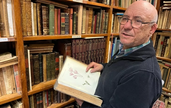 David Rodés muestra un libro antiguo con ilustraciones / TC