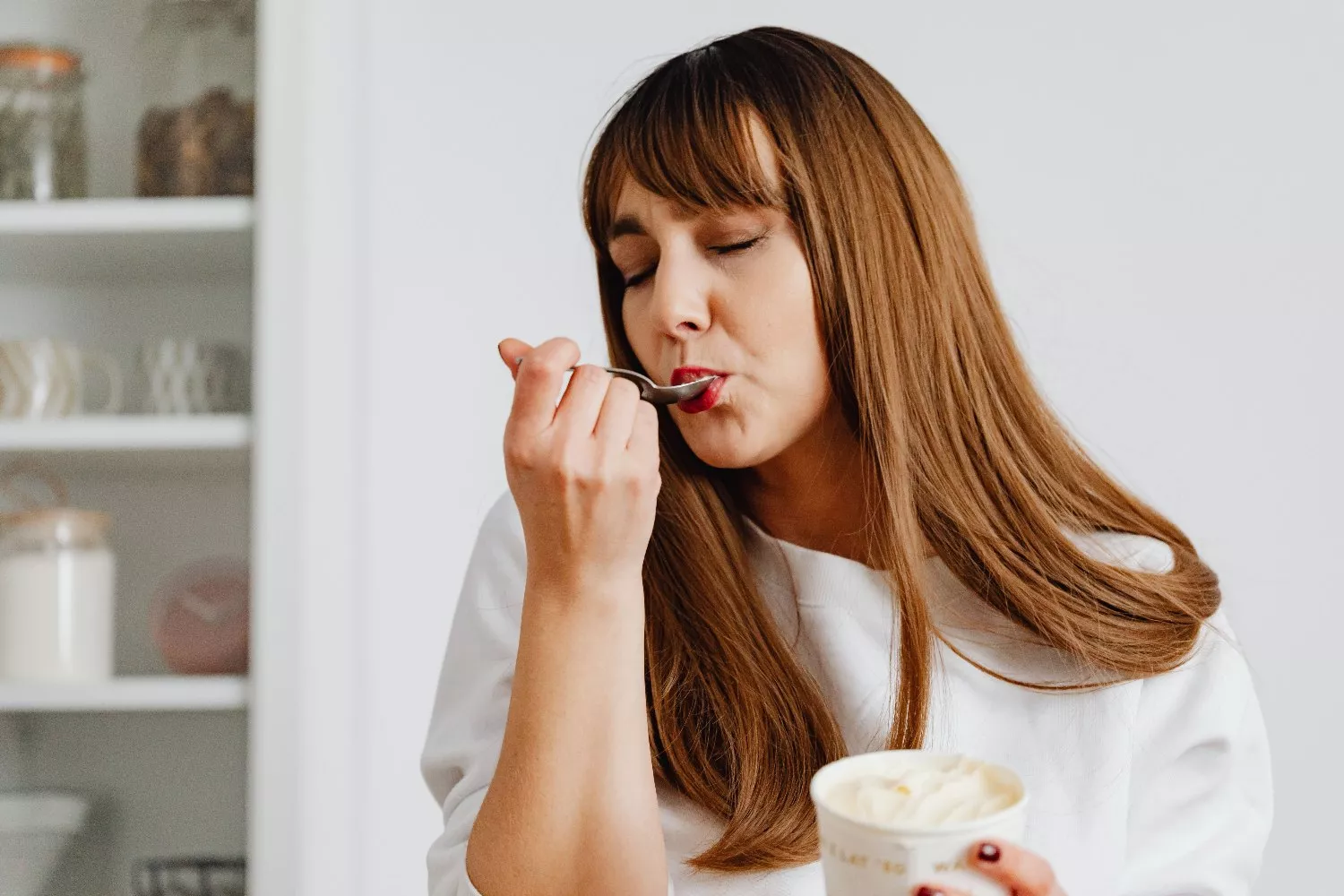 Una persona disfruta una tarrina de helado / PEXELS