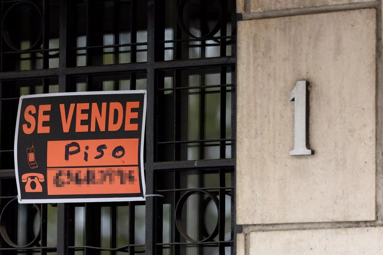 Vista de un cartel de 'Se vende' en un portal de un edificio