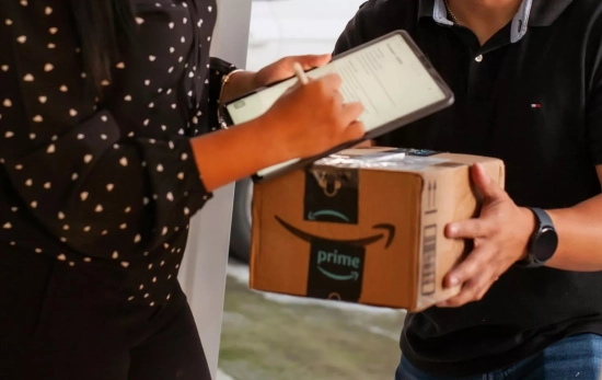 Una persona con un paquete de Amazon / PEXELS