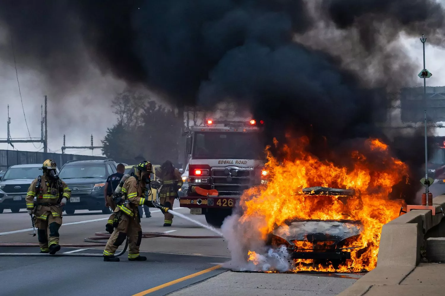 Un coche en llamas y varios bomberos