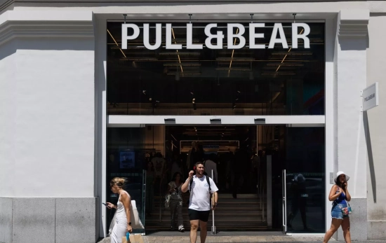 Varias personas pasan por delante de una tienda de Pull&Bear del grupo textil Inditex Varias personas pasan por delante de una tienda de Pull&Bear del grupo textil Inditex