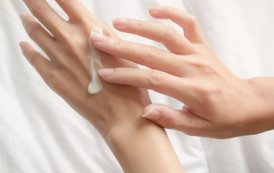 Una persona aplicándose crema en las manos/ CANVA Una persona aplicándose crema en las manos/ CANVA